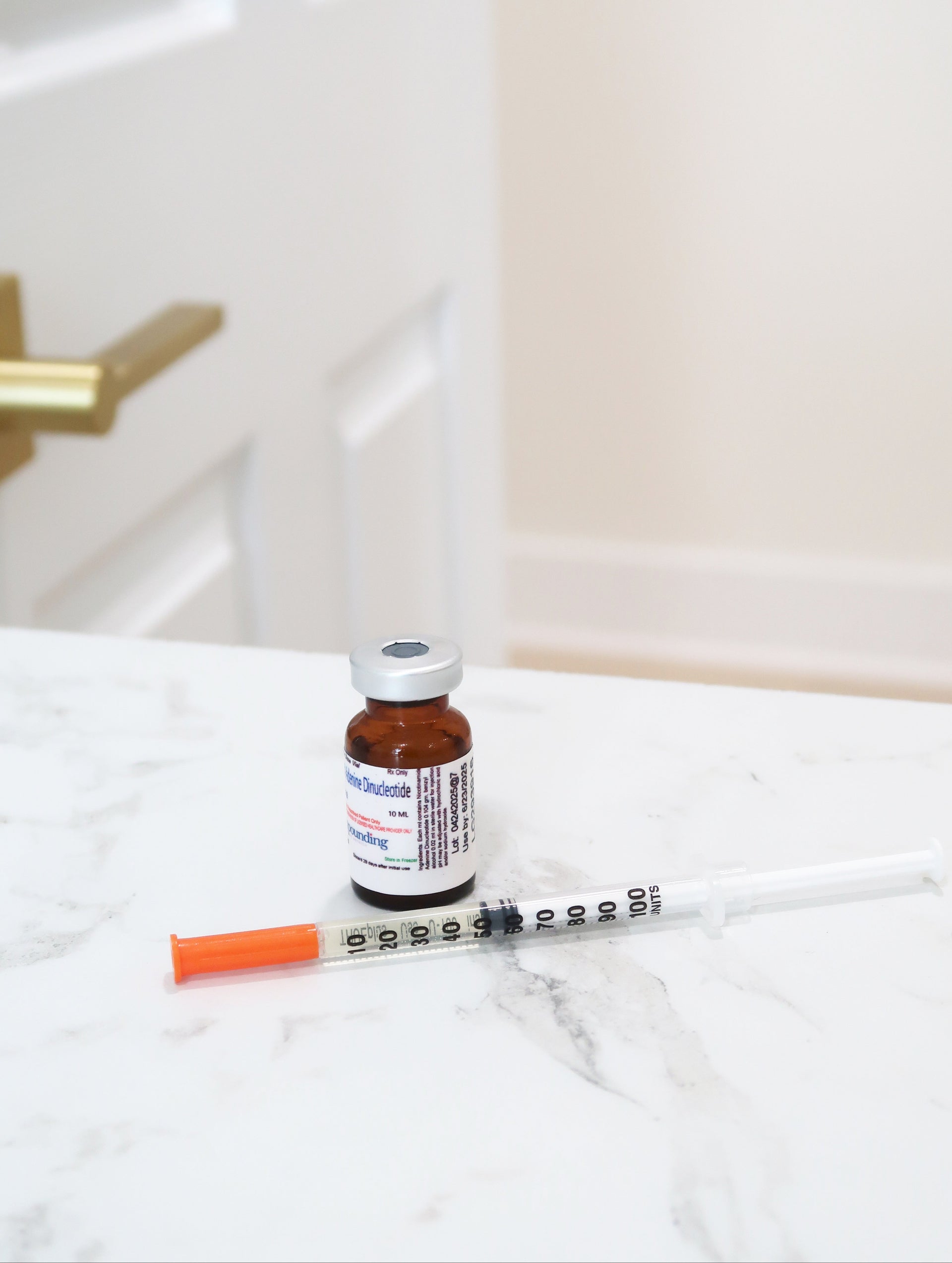 Vial and syringe on a white surface with a blurred background